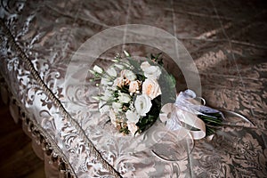 A bride`s bouquet lies on the bed