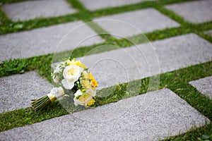 The bride s bouquet lies on the surface of the plates, between which grass grows
