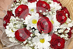 Bride`s bouquet of red roses and white daisies