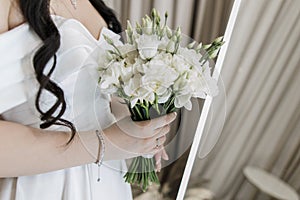 Bride's delicate grasp on elegant white bouquet