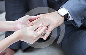 Bride's hand putting a wedding ring