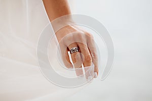Bride`s hand with ring and veil