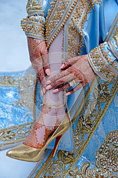 The bride`s hand is tattooed with henna. The bride wears an Arab caftan photo