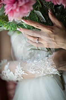 Bride`s hands with flowers . bouquet in hands of the bride, woman getting ready before wedding ceremony .