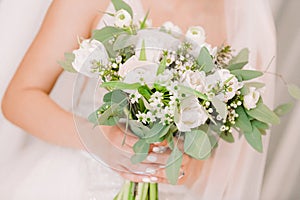 Bride`s hands hold beautiful bridal bouquet