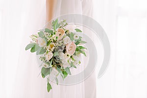 Bride`s hands hold beautiful bridal bouquet