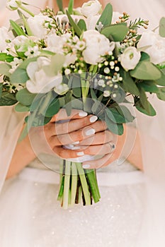 Bride`s hands hold beautiful bridal bouquet