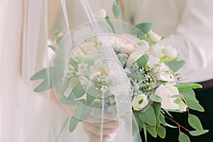 Bride`s hands hold beautiful bridal bouquet