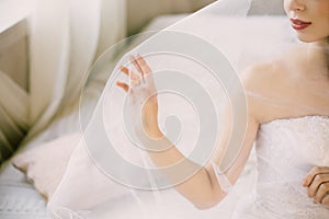 Bride`s morning. Fine art wedding. Portrait of a young beautiful tender bride with red lips in white lace wedding