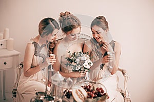 Bride`s morning . happy bride and her girlfriends with glasses of wine