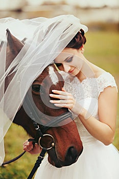 Bride`s veil covers a brown horse head