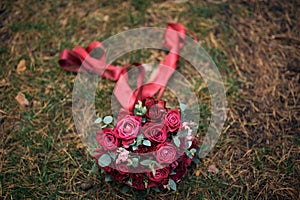 BrideÃ¢â¬â¢s wedding bouquet, red flowers on grass background