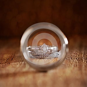 Bride`s wedding and engagement rings photographed through groom`s ring