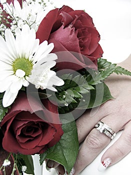 Bride's wedding ring hand and bouquet closeup