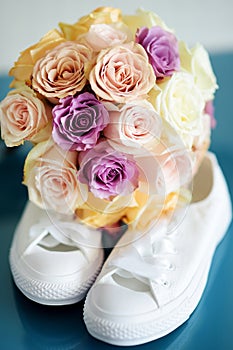 Bride`s white sneackers and beautiful bridal bouquet photo