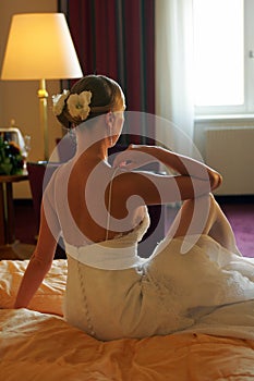 Bride sat on bed rear view