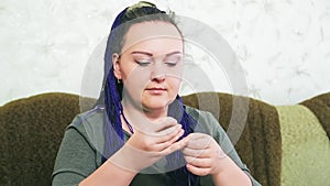 The bride sews a wedding dress by hand with a needle and thread for herself.