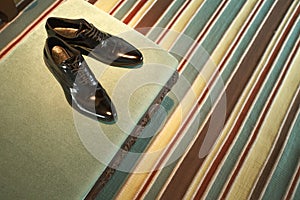 Bride shoes near canopy bed in beautiful room.