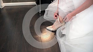 The bride shoes the shoe and fastens the strap