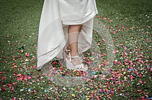 Bride shoes stepping on confetti on the floor