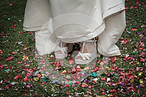 Bride shoes stepping on confetti on the floor