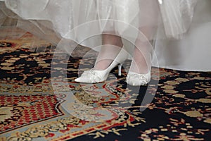 Bride shows her wedding white shoes