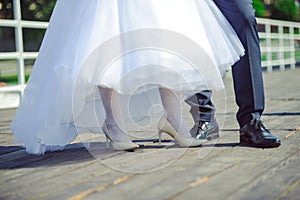 The bride shows white wedding shoes. Wedding detail. Close up