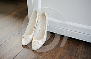 The bride shows white wedding shoes. Wedding detail. Close up