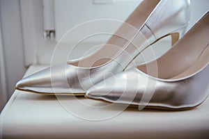 The bride shows white wedding shoes. Wedding detail. Close up