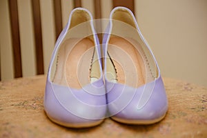 The bride shows white wedding shoes. Wedding detail. Close up