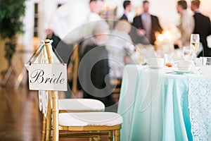 Bride sign hanging on chair at a wedding reception.