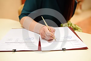 Bride signing marriage license or wedding contract during ceremony