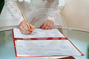 Bride signing signature on wedding certificate