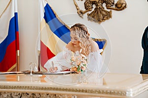 bride signs the marriage certificate in the registry office.