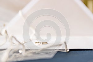 A bride silitair diamond ring with a vail and  wedding invitations