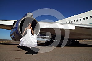 Bride sitting in engine of retired commercial airplane