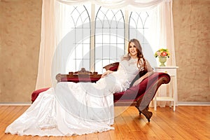 Bride sitting on fainting couch by window