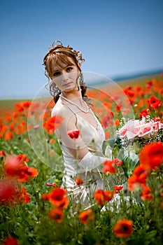 Bride sitting in field of flowers