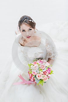 Bride sitting and holding a bouquet of flowers
