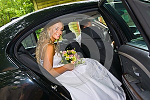 Bride sitting in a limousine photo