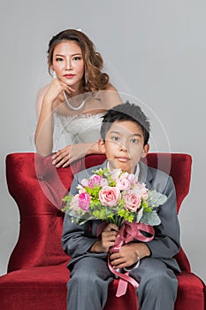 Bride sitting with son, he holding a bouquet