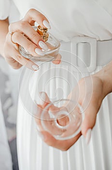 The bride splashes perfume on her wrist