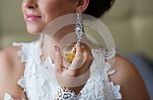 Bride spraying perfume on her neck