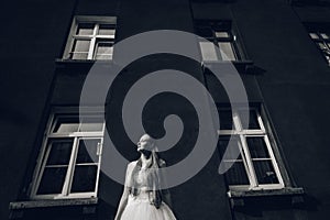 The bride is standing in front of the building