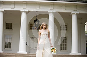 Bride standing in front of pillared porch