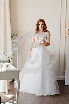 Bride in stands near wall waiting of ceremony