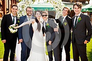 Bride stands together with funny groomsmen