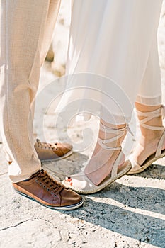 Bride stood on tiptoes next to groom. Cropped. Faceless photo