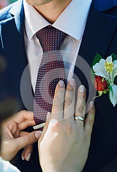 Bride straightens to groom his tie.