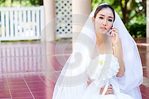 Bride talking on cell phone in wedding dress